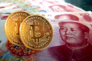 Duas moedas de bitcoin e cédulas da moeda chinesa Yuan Renminbi
