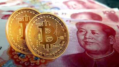 Duas moedas de bitcoin e cédulas da moeda chinesa Yuan Renminbi
